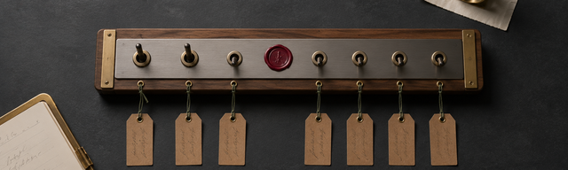 Walnut-and-brass control board with seven brass toggle switches on matte dark slate, three switches lifted, a single oxblood wax-seal accent between the rows — metaphor for seven Symfony CVEs jointly inspected and cleared in a single maintenance window.